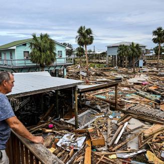 Man on deck looking out over field of storm debris