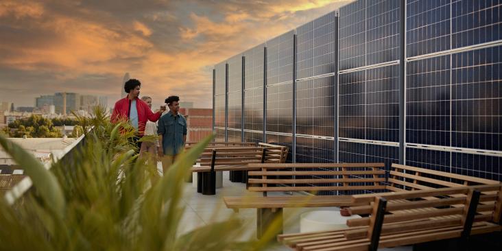 Young people on a rooftop examining solar panels