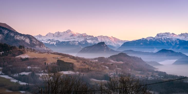 Sweeping, scenic view of a snow-capped mountain landscape with blue and purple tones