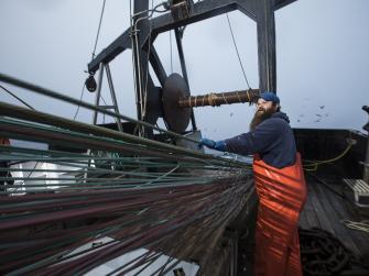 Fisherman on a boat reeling in a net