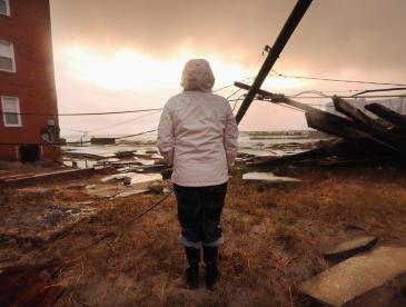 person looks out at destruction after a hurricane