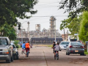 Kids bike in the streets of their Baytown, Texas neighborhood near oil and gas infrastructure.