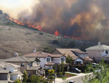 Brush fire burning near hillside homes.